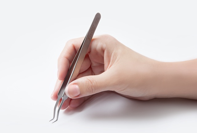 Image demonstrating proper hand positioning and tweezer handling for lash artists. Emphasizes the importance of reducing wrist and hand strain, ensuring accuracy during long lash sessions
