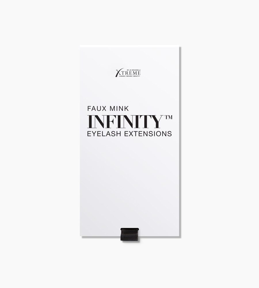 A close-up, highly magnified image of a single black Xtreme Lashes lash extension.