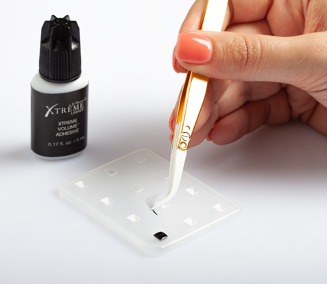 Eyelash extensions application tools, including adhesive and precision tweezers, designed for creating custom lash looks with professional accuracy.